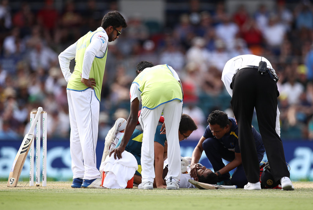 Sri Lanka's physio checks on Dimuth Karunaratne after he is hit on the head by a Pat Cummins bouncer © Getty Images