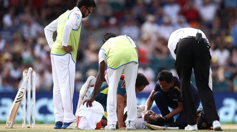 Sri Lanka's physio checks on Dimuth Karunaratne after he is hit on the head by a Pat Cummins bouncer © Getty Images