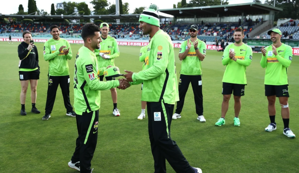 Gurinder Sandhu presents a cap to Afghanistan's Fazalhaq Farooqi•Dec 13, 2022•Getty Images