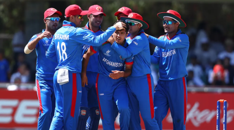 Fazal Haque is congratulated by his team-mates • Matthew Lewis-ICC/ICC via Getty Images